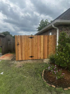 A newly installed wooden privacy fence gate on the side of a house by J&L Fence in Zolfo Springs, FL.