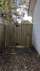 A wooden privacy fence with a gate installed in a side yard by Gifford Contracting & Repair - Custom Privacy Fencing in Goose Creek, SC.