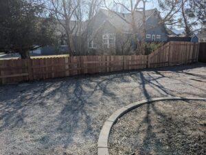 A well-built wooden privacy fence bordering a gravel driveway by Finest Fence in Simi Valley, CA.