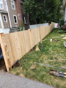 A wooden privacy fence installation in progress with tools on the ground by Matul Fence Inc in Lynn, MA
