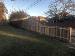 A newly installed wooden privacy fence with a gate along a property line by Paragon Fence, LLC in Colorado Springs, CO.