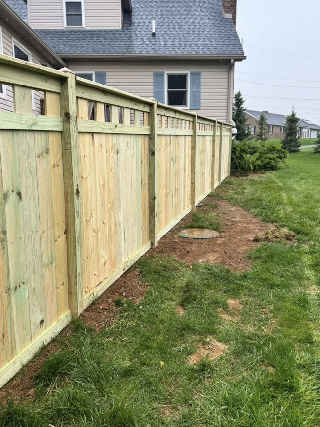 A newly installed wooden privacy fence by Red Gate Fencing in Allentown, PA, bordering a residential backyard.