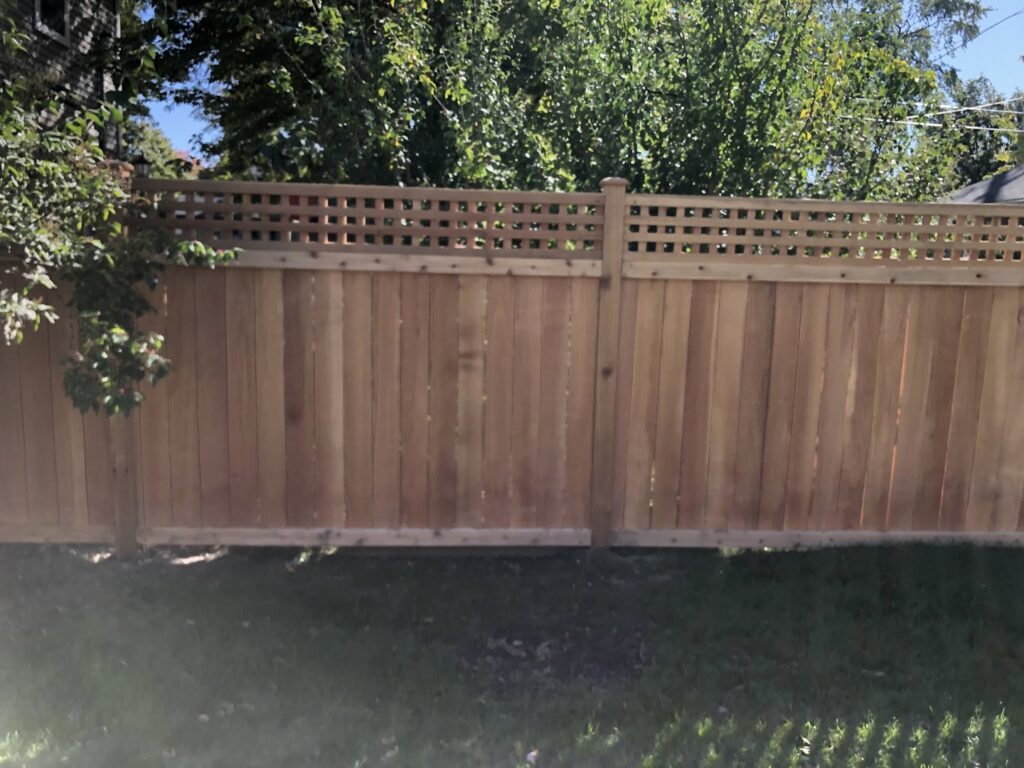 A wooden privacy fence with a lattice top enclosing a backyard by Freeman Fence in Atlanta, GA.