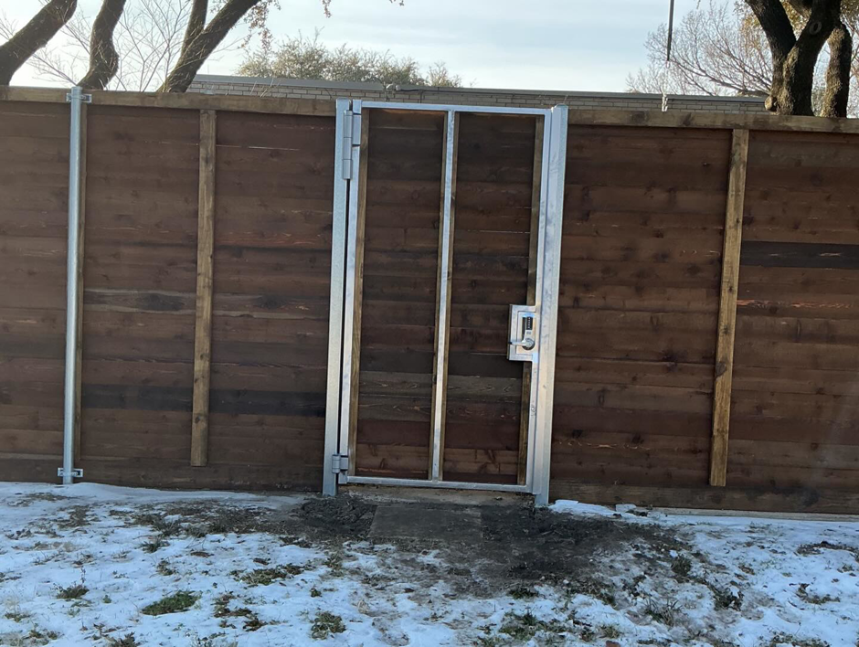 A new wooden privacy fence with a sturdy metal gate frame installed by B & S Fence Company in Haltom City, TX