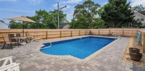 A newly installed wooden privacy fence surrounding a swimming pool area by MAC Fencing LLC in Toms River, NJ