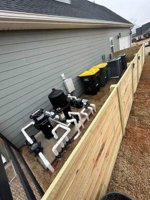 A wooden privacy fence enclosing pool equipment and trash cans installed by Georgia Select Fence in Senoia, GA.