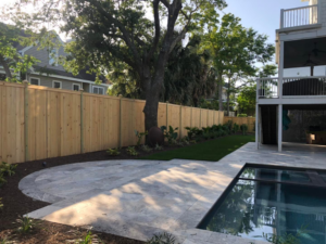 A sturdy wooden privacy fence bordering a backyard with a pool and patio by Lowcountry Home Works843 LLC in Summerville, SC.