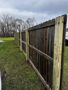 A newly repaired wooden privacy fence with fresh posts by Gator Fence Co. in Miami, FL
