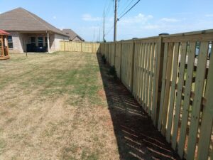 A newly installed wooden privacy fence in a residential backyard by Kelley Fence and Gate in Eva, AL.