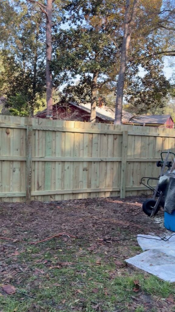 A wooden privacy fence under construction in a residential area by Julien Affordable Fencing LLC in Jacksonville, FL