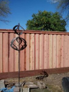 A newly installed wooden privacy fence with a decorative metal spinner by Sacramento Valley Fencing in Sacramento, CA.