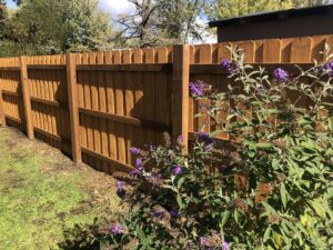 A newly installed wooden privacy fence with decorative top rails by Pacific Woods Fence and Deck in Springfield, OR.