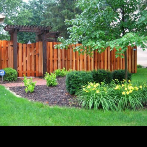 A beautiful wooden privacy fence with an integrated gate and pergola installed by McDaniels Fencing in Huntington, WV.