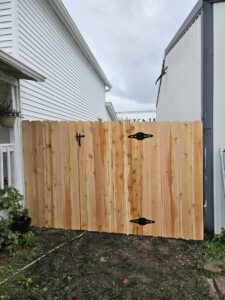 A newly installed wooden privacy gate with black hardware by JM Fence Works in Davenport, IA.