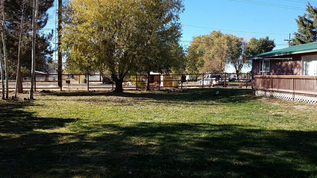 A wooden rail fence enclosing a residential yard, installed by Idaho Falls Fencing in Idaho Falls, ID.