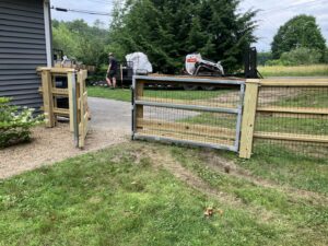 A wooden rail fence with wire mesh and a double gate installed at a residential property by Doolan Fence in Montpelier, VT.