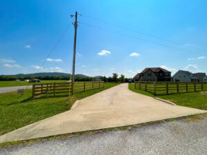 A long wooden split-rail fence with wire mesh installed along a residential driveway by Pro Fence in Decatur, AL