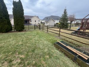 A wooden split-rail fence with a gate installed in a backyard by Premier Fence LLC in Canton, MA.