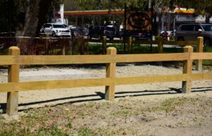 A newly installed wooden split-rail fence along a commercial property or roadside by Five Star Fence in Charleston, SC.