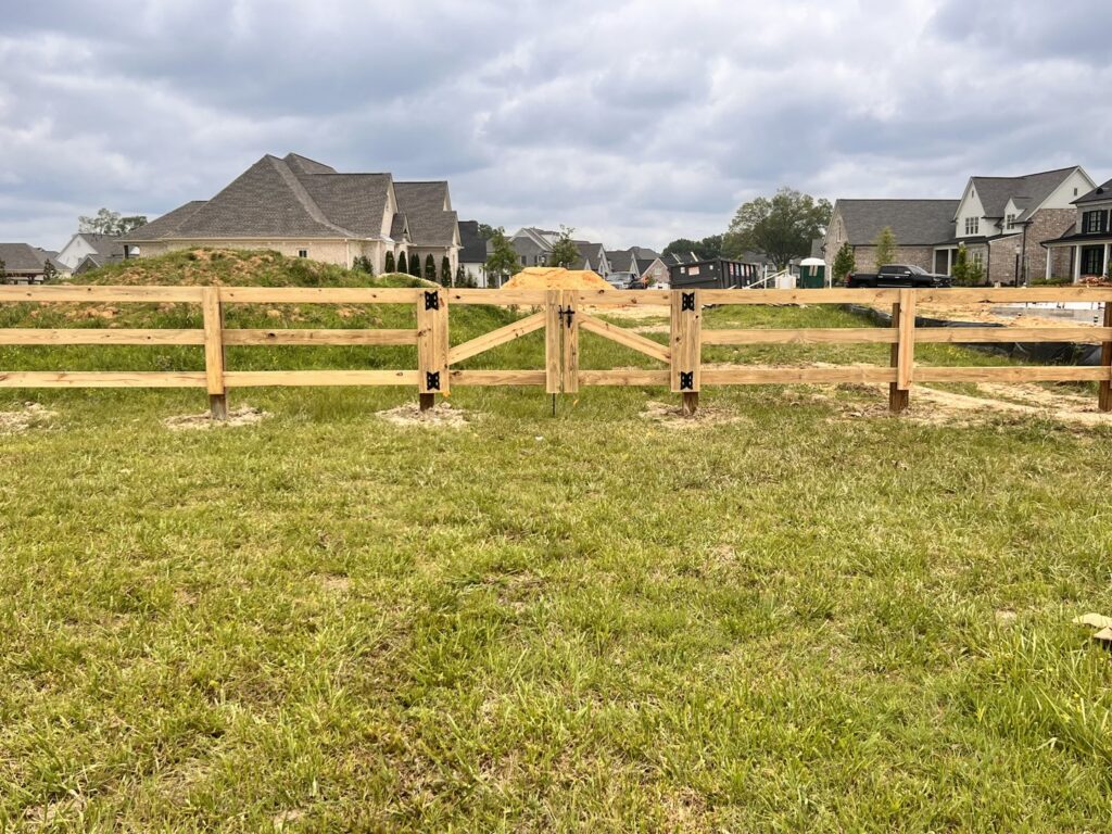 A new wooden split-rail fence with a matching gate installed by First Responder Outdoor Construction LLC in Bartlett, TN.