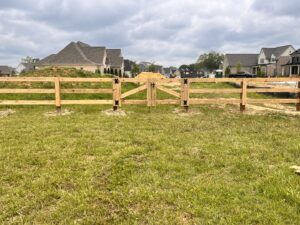 A new wooden split-rail fence with a matching gate installed by First Responder Outdoor Construction LLC in Bartlett, TN.