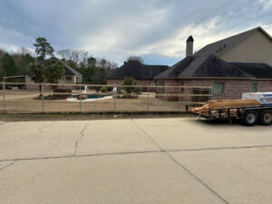 Installation of a wooden split-rail fence around a large backyard with a pool by Lynch's Temporary Fencing & Dumpster rental in Bossier City, LA.