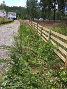 A newly installed wooden split-rail fence along a property line by Castillo Fences in Sacramento, CA.
