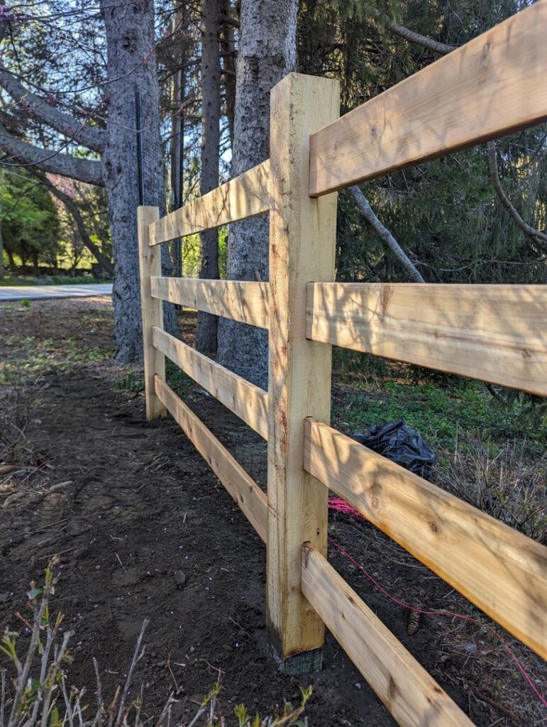 A newly installed wooden split-rail fence by Fence Pros Direct in Saunderstown, RI.