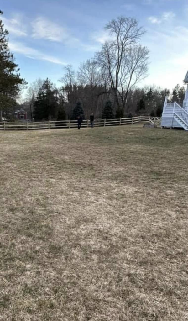 A long wooden split-rail fence installed across a large property by Hunter & Sons Fence in Arlington, MA.