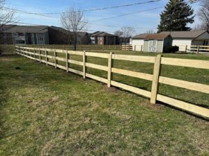 A newly installed wooden split-rail fence in a grassy area by Render Fences in Fishers, IN.
