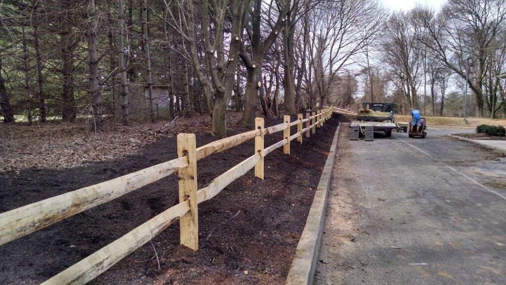 A wooden split-rail fence installed along a path by Snyders Custom Fencing in York, PA.