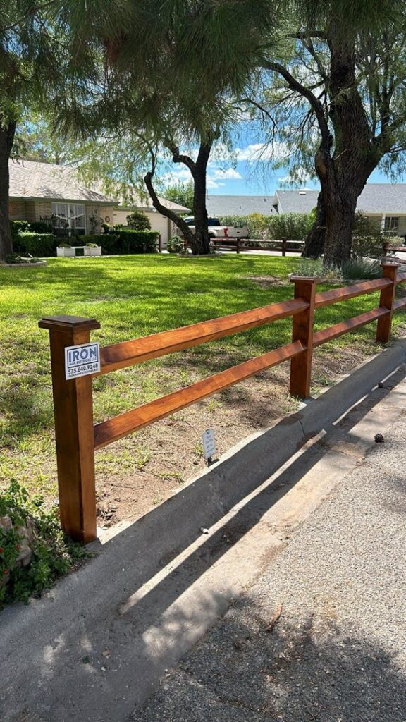 A wooden split-rail fence along a residential street by Iron Man Exteriors in Las Cruces, NM.