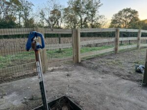 A wooden split-rail fence with wire mesh bordering a field, installed by D&M Renovation Services LLC in Columbus, OH.