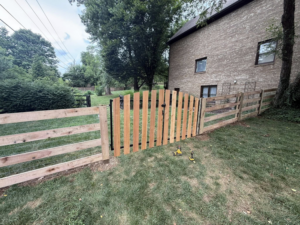 A wooden split-rail fence with wire mesh and a matching gate installed by JV Fences in Lexington, KY.