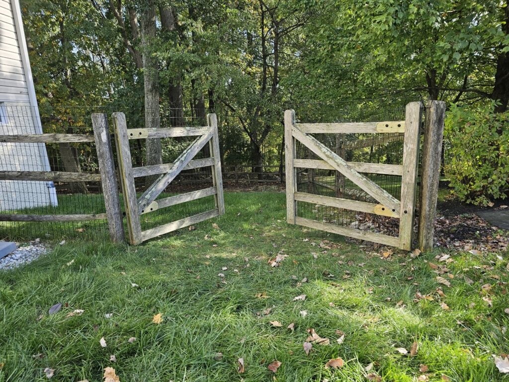 A rustic wooden split rail fence with wire mesh and two gates installed by Integrous in Gap, PA