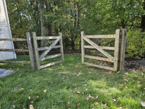 A rustic wooden split rail fence with wire mesh and two gates installed by Integrous in Gap, PA