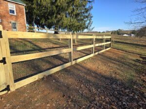 A newly installed wooden split-rail fence with wire mesh in a rural setting by Future Solutions Fence Supply in York, PA