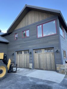 Two wooden-style garage doors installed on a modern building by Prutch's Garage Door of Colorado Springs, CO