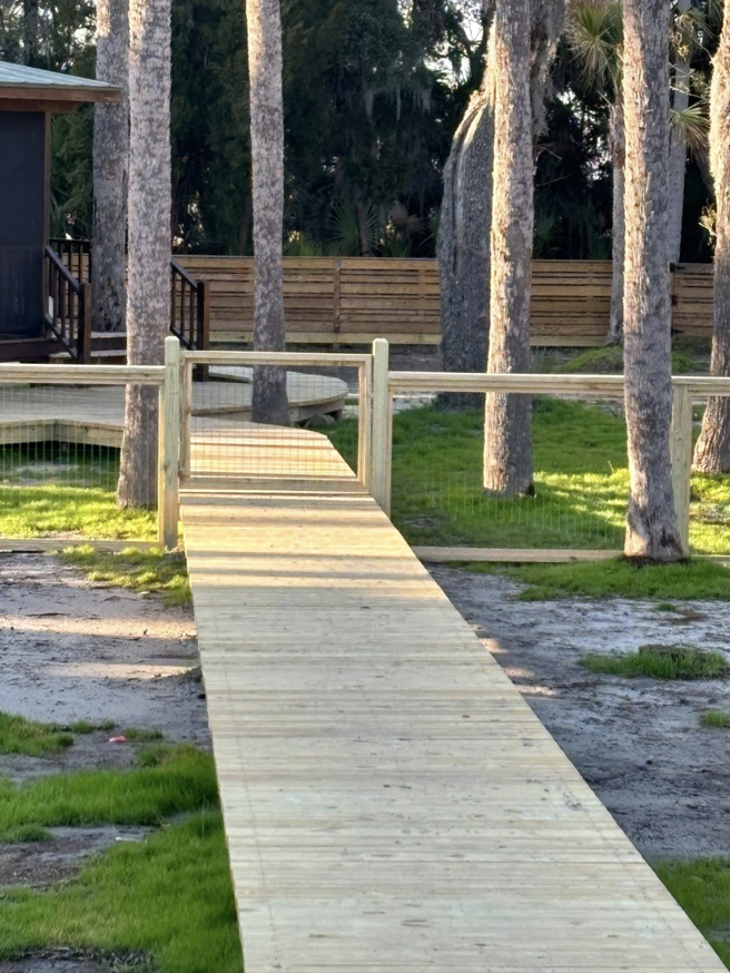 A newly installed wooden walkway with a low wire mesh fence, built by True Line Fencing LLC in Mount Pleasant, SC.