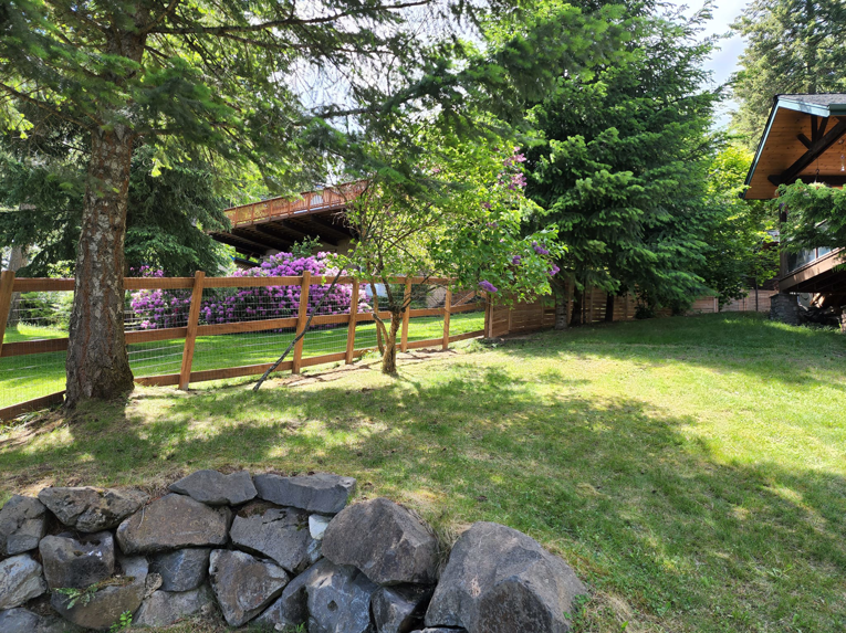 A newly installed wooden fence with wire mesh in a residential backyard by EcoGreen Fencing in Coeur d'Alene, ID.