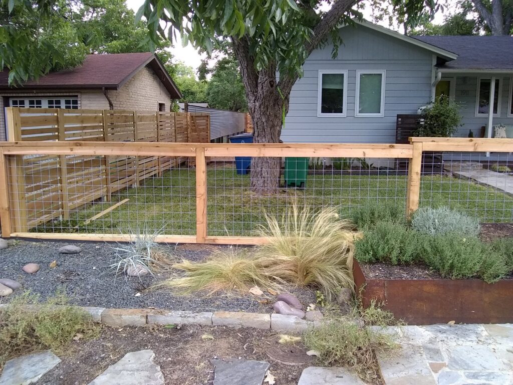 A wooden fence with wire mesh panels installed in a front yard by Landmark Fence & Deck Company in Saint Paul, MN.