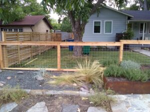 A wooden fence with wire mesh panels installed in a front yard by Landmark Fence & Deck Company in Saint Paul, MN.