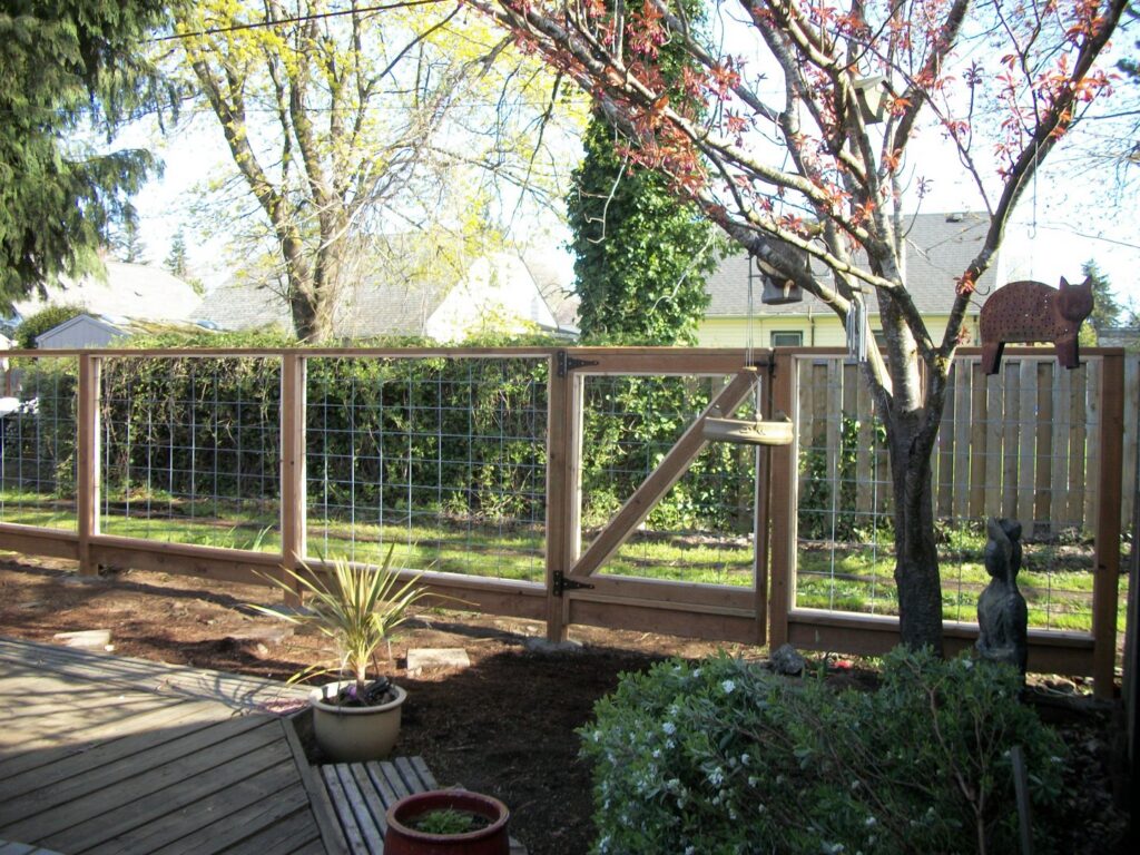 A wooden fence with wire mesh panels and a gate installed by Fix-A-Fence LLC in Portland, OR.