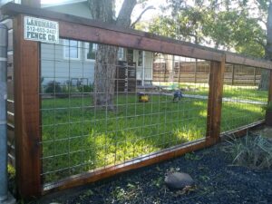 A wooden fence with wire mesh panels and a business sign by Landmark Fence & Deck Company in Saint Paul, MN.