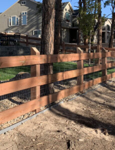 A wooden fence with wire mesh backing in a residential setting, built by Colorado Springs Fence Company in Colorado Springs, CO.