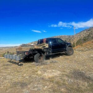 A work truck loaded with wooden fence posts and rolls of wire, ready for a fencing project by Cool Hand Fencing and Wyo War Wagons in Laramie, WY.