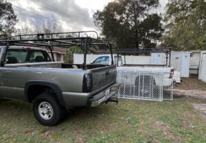 Two work trucks with ladder racks and a fence gate, ready for a job by Aarons fence in Homosassa Springs, FL