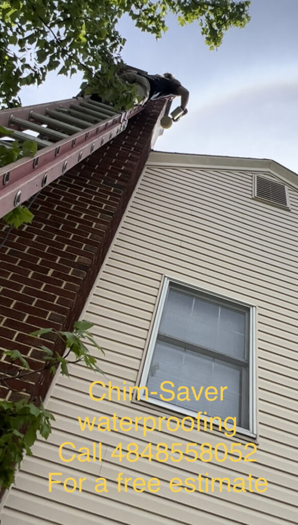 A worker on a ladder applying Chim-Saver waterproofing to a chimney for Maximum Energy Savers in Philadelphia, PA