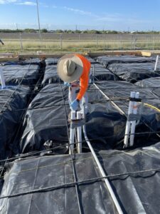A Solutions Pest Management worker applying pre-construction pest treatment to a foundation in Corpus Christi, TX.
