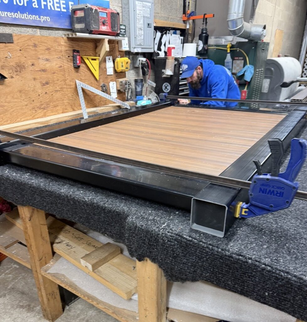 A worker assembling a fence panel in a workshop for Future Solutions Fence Supply in York, PA